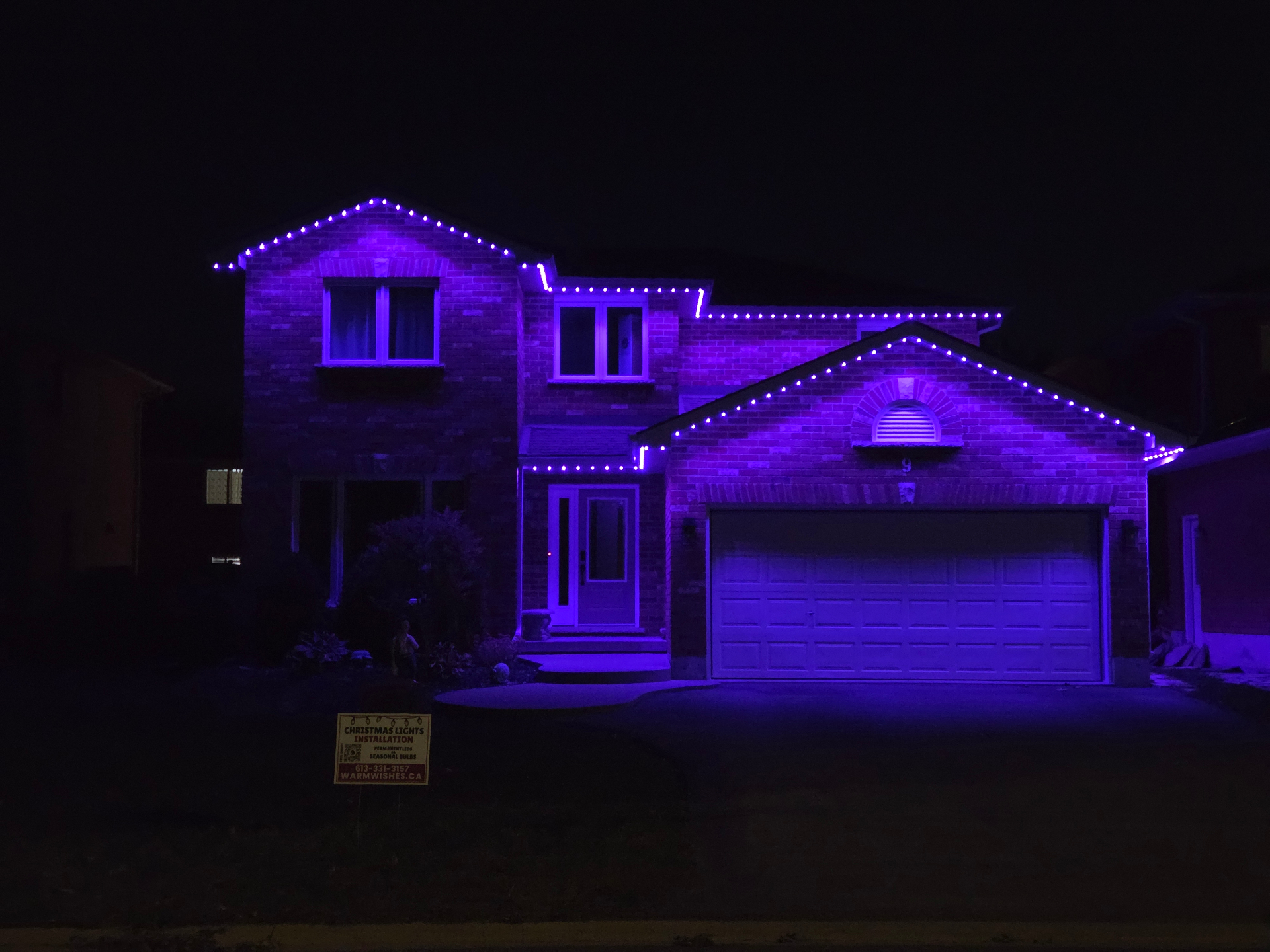 Belleville home glowing purple with permanent LED roofline lights for a themed night