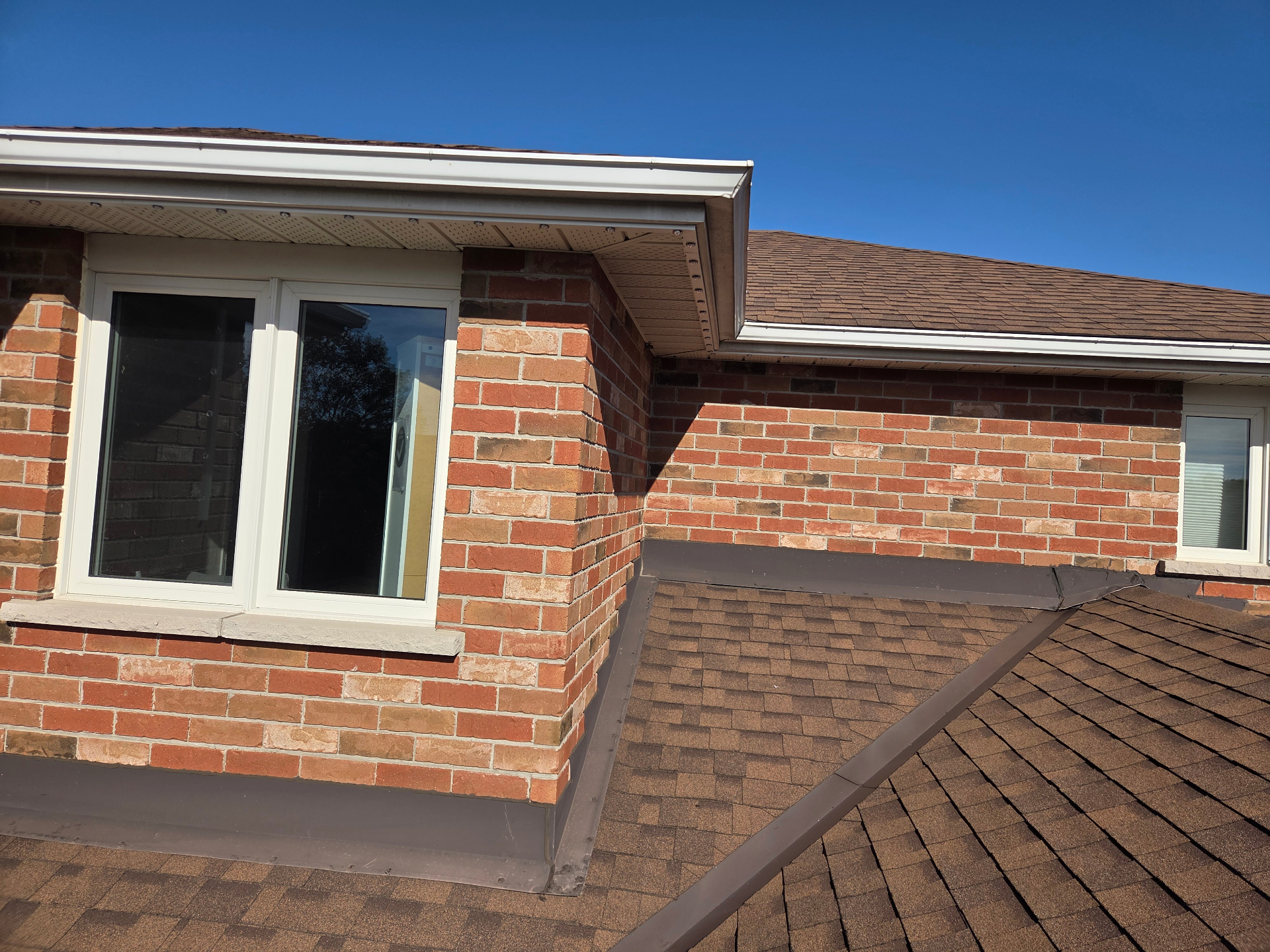 Close-up of permanent LED track fitted under the soffit of a Belleville brick home